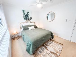 a bedroom with a bed and a mirror on the wall at 59 Short in Nambucca Heads +10 photos