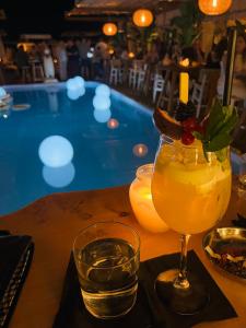 a drink on a table next to a swimming pool at C14 Apartment 1 in Paralia Katerinis