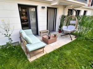 a patio with a chair and a swing at Boho style apartment - 7 mins from Paris Center - Garden and underground parking in Clamart