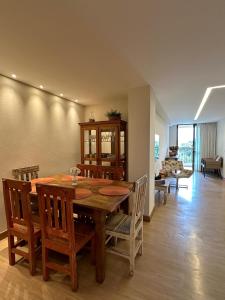 ein Esszimmer mit einem Holztisch und Stühlen in der Unterkunft Vista Azul Apart Hotel - Suite Vista Pedra Azul in Pedra Azul