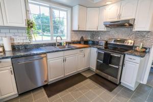 a kitchen with white cabinets and stainless steel appliances at Spacious Family Home with Hot Tub in Ellensburg