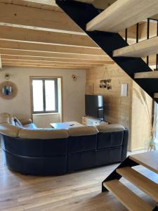 a living room with a large couch and a staircase at Maison Canelle Le Clos des Ours in Matemale