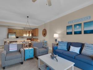 sala de estar con sofás azules y cocina en Sanctuary at Redfish 1119 by Newman-Dailey, en Santa Rosa Beach