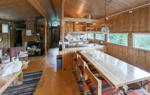a kitchen with wooden walls and a large wooden table at Beautiful Home In Jordet in Jordet