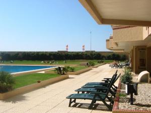 Una fila de bancos junto a un edificio. en Holidays appartment, en Furadouro