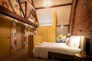 a bedroom with a bed and a brick wall at Boetiekhotel op de Platz in Limbricht +48 photos