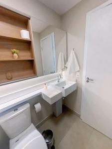 a bathroom with a toilet and a sink and a mirror at Studio Quirino- novo e moderno in Campinas