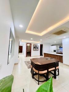 a living room with a table and a kitchen at Luxurious Appartment in GOLDCREST DHA Lahore in Lahore