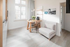 ein Wohnzimmer mit einem Tisch und einem Stuhl in der Unterkunft Nordstrandperle Ap H6 in Norderney