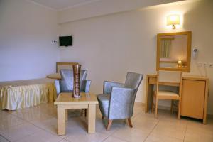 ein Schlafzimmer mit einem Bett, einem Tisch und Stühlen in der Unterkunft Theofilos Superior Hotel in Petra