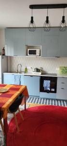 a kitchen with a wooden table and a red rug at Paris/La Défense 10' en train 2 CHB in Colombes
