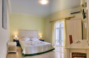 ein Schlafzimmer mit einem großen weißen Bett und einem Fenster in der Unterkunft Theofilos Superior Hotel in Petra + 56 Fotos