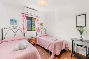 twee bedden in een kamer met roze lakens bij Villa Cecilia Sol in Torrox