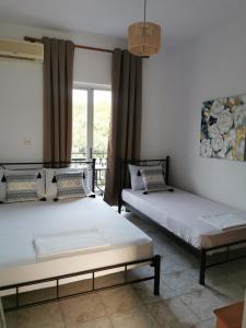 two beds sitting next to each other in a room at Villa Adamidis in Paralía Skotínis
