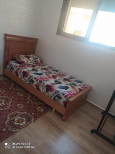 a bedroom with a bed and a window and a rug at Bouznika Dahoumi Mandarona in Bouznika +6 photos