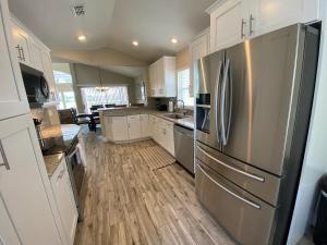 una cucina con frigorifero in acciaio inossidabile e mobili bianchi di 8th Fairway Holiday Home Updated Southern Dunes a Haines City