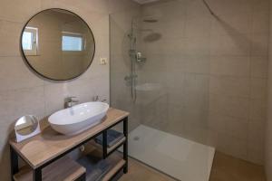 Un baño con lavabo y ducha con espejo. en Apartman Zgodić, en Tuliševica 25 fotos más