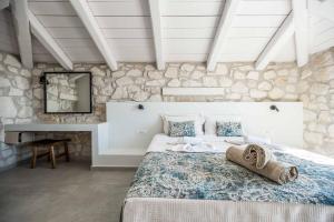 a bedroom with a large bed in a stone wall at Villa Maria Vasilikos in Xirokástellon +35 photos