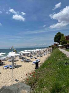 a beach with chairs and umbrellas and the ocean at 'Oasis' Ravda Apartment, Nessebar in Ravda