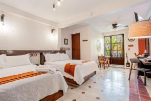 ein Hotelzimmer mit zwei Betten und einem Klavier in der Unterkunft Kuxtal Hotel Boutique in Mérida + 25 Fotos