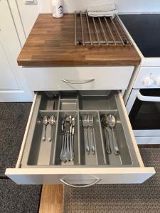 a kitchen sink with utensils in a drawer at SiilinPiha central apartament Siilinjärvi in Siilinjärvi