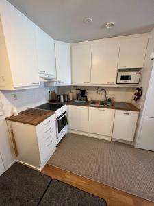 a kitchen with white cabinets and a stove top oven at SiilinPiha central apartament Siilinjärvi in Siilinjärvi +7 photos