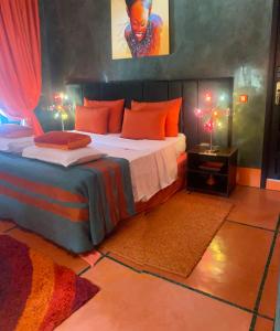 um quarto com uma cama grande e almofadas laranja em Villa Mano em Marraquexe