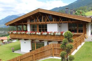 a house with a balcony with flowers on it at Landhaus Eiter in Arzl im Pitztal