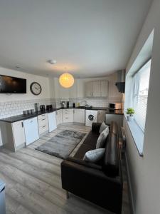 a living room with a couch and a kitchen at Cosy Modern Apartment in Warrington +33 photos