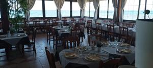 a dining room with tables and chairs and the ocean at B&B Cristina in Torricella +41 photos
