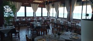 a dining room with tables and chairs and the ocean at B&B Cristina in Torricella