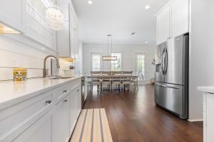 a kitchen with white cabinets and a stainless steel refrigerator at Uncloudy Day - 1216 Demere Road in Mallory Park