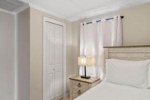 a bedroom with a bed and a lamp on a night stand at Beachside Retreat! Cozy 1-bedroom W Private Yard in Dennis