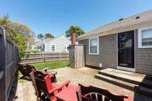 a patio with two red chairs and a table at Beachside Retreat! Cozy 1-bedroom W Private Yard in Dennis