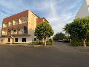 a building with a parking lot in front of it at Hotel Califórnia in Tangara da Serra