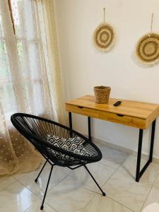 a chair sitting in front of a desk with a table at Skopelos Inn in Stafylos