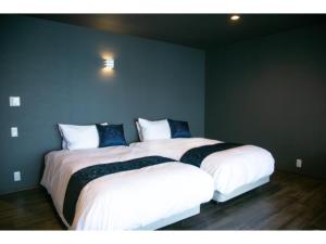 two beds sitting next to each other in a room at Setouchi Resort Hotel - Vacation STAY 95867v in Matsuyama