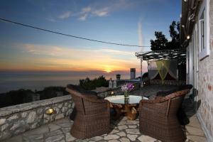 a patio with a table and chairs and a sunset at dreamOn in Lefkada