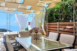 a glass table and chairs on a patio at dreamOn in Lefkada