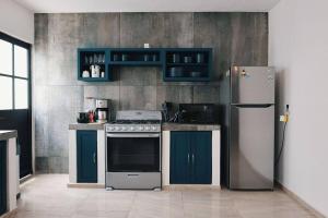 a kitchen with a stove and a refrigerator at Casa Ji-Có, Bacalar in Bacalar