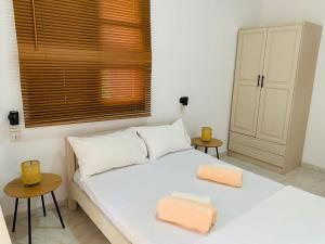 a bedroom with a white bed with two towels on it at Skopelos Inn in Stafylos