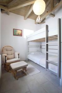 a bedroom with a bunk bed and a chair and a chair at dreamOn in Lefkada
