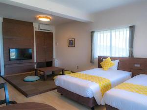 a hotel room with two beds and a flat screen tv at Hotel Sunset Hill - Vacation STAY 94801v in Nakadomari