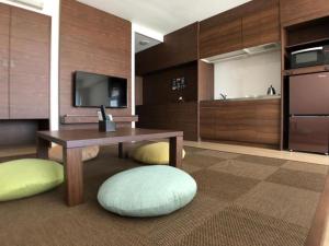 a living room with a table and a television at Hotel Sunset Hill - Vacation STAY 94794v in Nakadomari +20 photos