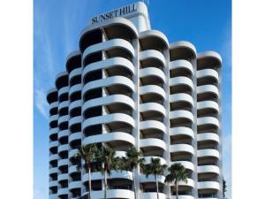 a tall building with palm trees in front of it at Hotel Sunset Hill - Vacation STAY 94794v in Nakadomari