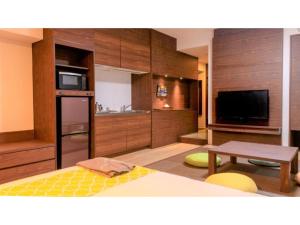 a room with a kitchen with a table and a tv at Hotel Sunset Hill - Vacation STAY 94797v in Nakadomari
