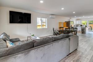 a living room with a large couch and a kitchen at Charming Westport Abode with Hot Tub, Deck and Yard! in Westport