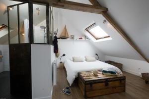 sypialnia z białym łóżkiem i drewnianym stołem w obiekcie Appartements du Port w mieście Port-en-Bessin-Huppain