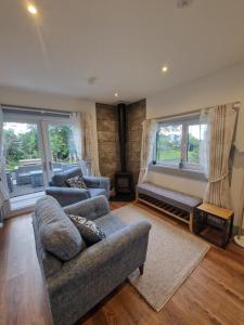 a living room with two couches and a large window at The Cabin at the Port in Portrush