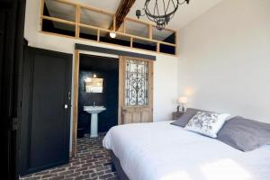 a bedroom with a bed and a sink and a window at Orangerie du chateau in Hugleville-en-Caux +10 photos